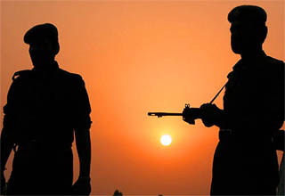 Policemen stand guard as the sunsets in Jammu