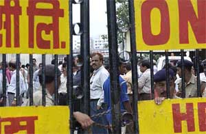 Relatives of the crash victims wait outside the ONGC office for the bodies to arrive