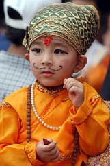 A child, wearing a traditional Nepali dress, observes the Gaijatra festival in Kathmandu 