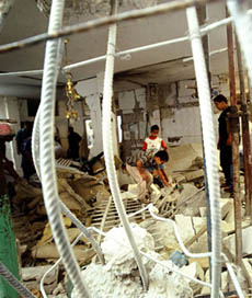 Palestinians search debris at the demolished home of suicide bomber Khamis Jarwan