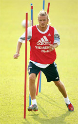 Real Madrid's David Beckham runs through poles during a training session in Madrid 