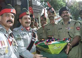 Pakistan�s Brigadier Sahi Marjan presents sweets to Indian battalion commander D. K. Sharma to mark Pakistan�s 56th independence day celebrations
