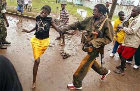 A female looter is beaten with a plastic electrical cord