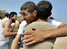 Palestinian prisoners hug each other as they arrive from an Israeli jail at the Salem checkpoint