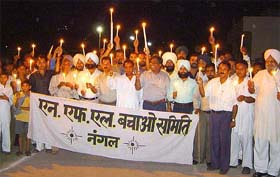 Residents of Nangal and workers of National Fertilisers Limited take out a candlelight march against disinvestment policies of the NDA government