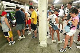 People wait at Times Square subway station in New York on Saturday