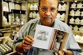 Dayalji Pattni, a Ugandan Asian, shows an album with a photograph of former Ugandan dictator Idi Amin