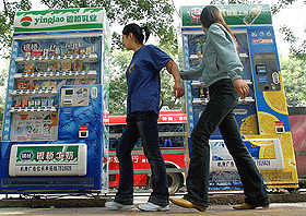 Chinese women walk past newly-installed vending machines in Xian