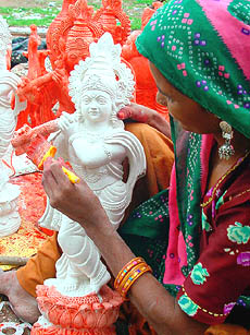 An artist paints a statue of Lord Krishna on the eve of Janmashtami in Bhopal 