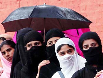 Veiled Kashmiri women wait in a queue outside the Bakhshi Stadium to collect application forms for mobile connection in Srinagar 