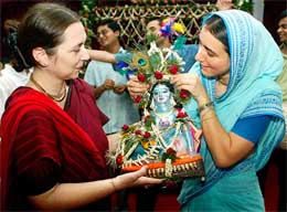 Devotees from the International Society For Krishna Consciousness decorate an idol of Lord Krishna