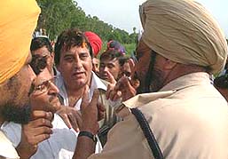 Union Minister of State for External Affairs Vinod Khanna argues with a police official as he leads his supporters towards the bridge in Naushehra Pattan on Wednesday.