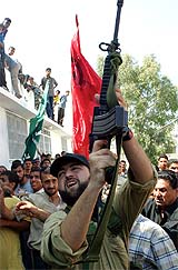 A Hamas gunman shoots into air during the funeral of Hamas leader Ismail Abu Shanab in Gaza City