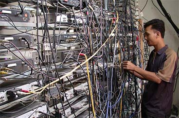 A Pakistani cable operator works in his shop