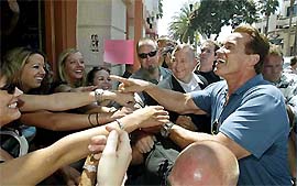 Arnold Schwarzenegger, Republican candidate for the post of California Governor, reaches out to greet his admirers in the southern California coastal city of Huntington Beach 