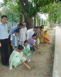 Ms Varsha Rampal, councillor of Ward No. 41, plants a sapling along with residents at a vanamahotsava