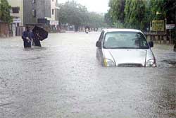 After heavy downpour, a car seen submerged in a waterlogged street