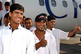 Unidentified members of the Iraqi national soccer team wave to the media on their arrival in Munich 