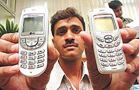 A policeman showing the mobile phones, seized from three conmen at a press conference in the Capital on Friday