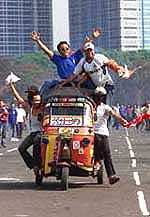 Bajaj drivers celebrate their victory in a race between three-wheeled passenger vehicles in Jakarta