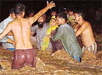Villagers rescue a woman passenger of the Punjab Roadways ill-fated bus