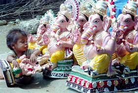 A child plays with an idol of Lord Ganesha