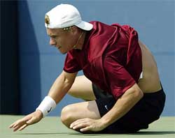 Australia's Lleyton Hewitt rolls on the court after stretching to make a shot against Radek Stepanek of the Czech Republic