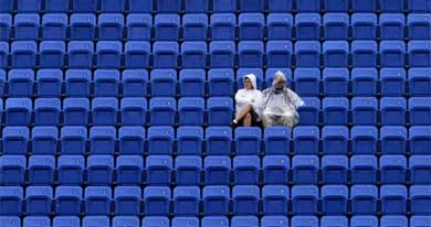 Two tennis fans wait in the stands