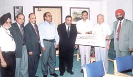 Mr S. S. Kohli, CMD, Punjab National Bank, presenting a cheque of Rs 74. 28 crore as dividend for 2002-03, to Mr S. S. Sisodia