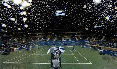 Stadium lights are reflected on glass as rain forces a halt in play at the US Open 