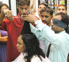 Ramjan Ali a teacher of blind students, teaches the finer nuances of a barber to his students