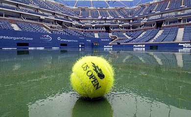 A tennis ball sits on the wet court at Arthur Ashe Stadium 