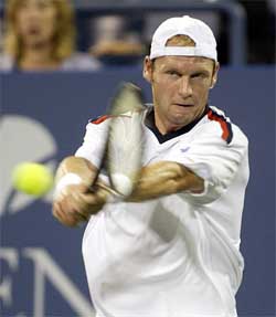 Rainer Schuettler of Germany hits a return to Sjeng Schalken of the Netherlands