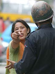 A pedestrian is stopped by a police officer in Kathmandu during a demonstration 