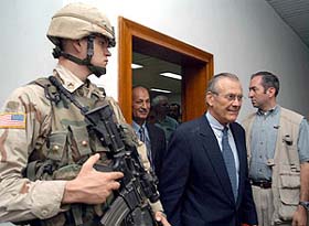 US Secretary of Defence Donald Rumsfeld is guarded by a US soldier
