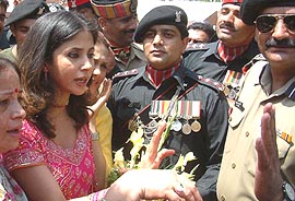 Cine star Urmila Matondkar presents a bouquet to a Pakistani Ranger at zero line during the music release function of Hindi film “Pinjar” at the Wagah joint checkpost on Saturday.