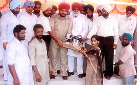 Mr Sadhu Singh Dharamsot, MLA, distributes sewing machines at a function at Faizullapur village, Amloh