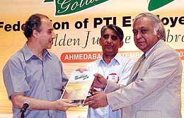 Union Minister for Communication and Information Technology Arun Shourie and ONGC chairman Subir Raha show a souvenir at the golden jubilee celebrations of Federation of PTI Employees� Union
