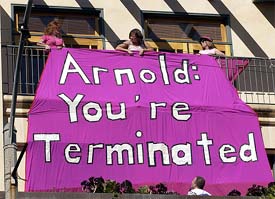 Members of the women's group Code Pink'un furl a banner in protest opposite the new campaign headquarters of actor Arnold Schwarzenegger 