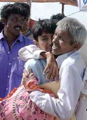 Ten-year-old Bhagwan Babu (centre) is hugged by his father Babubhai as he arrives at the port of Okha