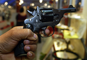 A visitor holds an Indian-made revolver during a defence exhibition in Kolkata