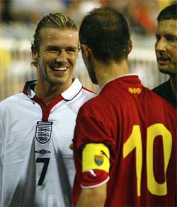 England captain David Beckham smiles as he is confronted by Macedonia's Artim Sakiri 