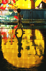 A boy walks past a giant lantern in the shape of the moon in Hong Kong