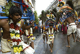 Hindu dancers with large arched frames decorated with peacock feathers celebrate Ganesh Chaturthi on the streets of Paris 