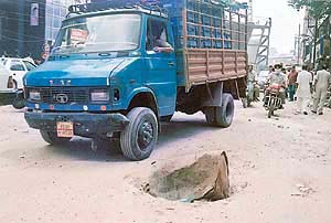 An empty coal tar drum being used as a manhole cover near Clock Tower on the G.T.Road.