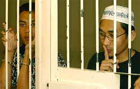 Indonesian youths Andi Hidayat and Abdul Rauf wait at a court detention