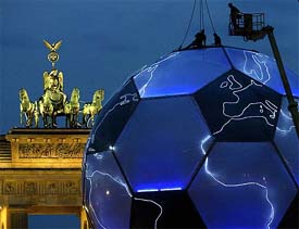 Technicians give final touches to a 2006 FIFA World Cup globe in front of Berlin's landmark Brandenburg Gate 