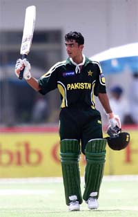 Pakistani batsman Yasir Hameed waves his bat to acknowledge the crowd's applause after reaching his century 