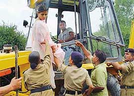 A woman who tried to stop the demolition drive in Kaimbwala village, north of the Sukhna Lake, on Wednesday, being brought down by police