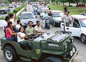 A girl joins an election rally on a jeep